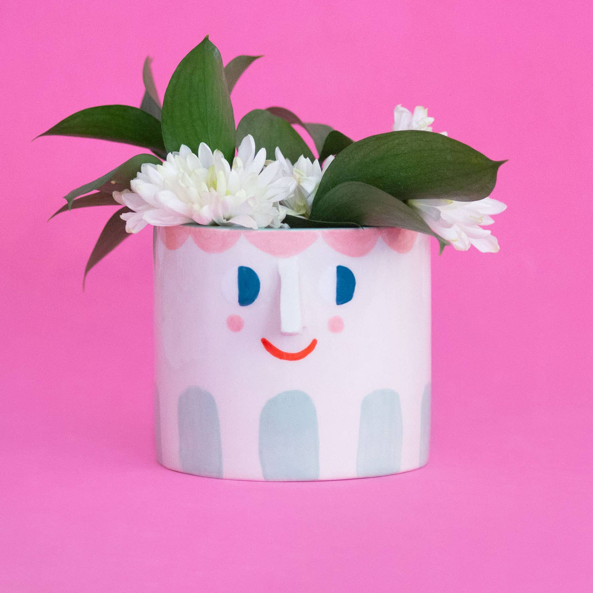 ceramic pot with cute face holding bouquet