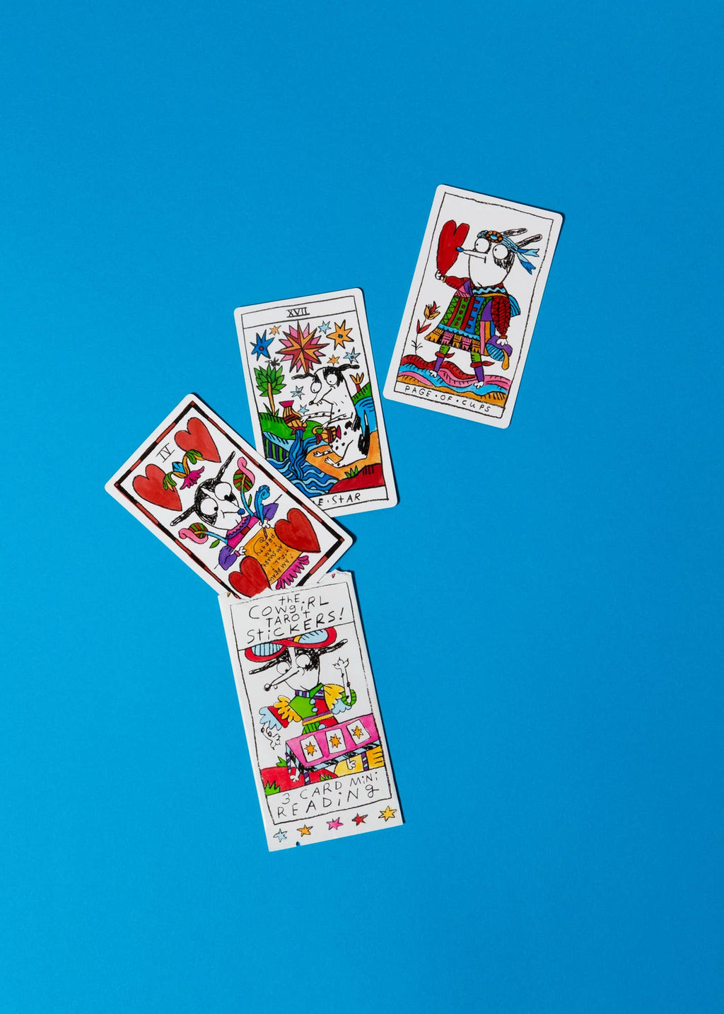 Four colorful tarot cards on a blue background