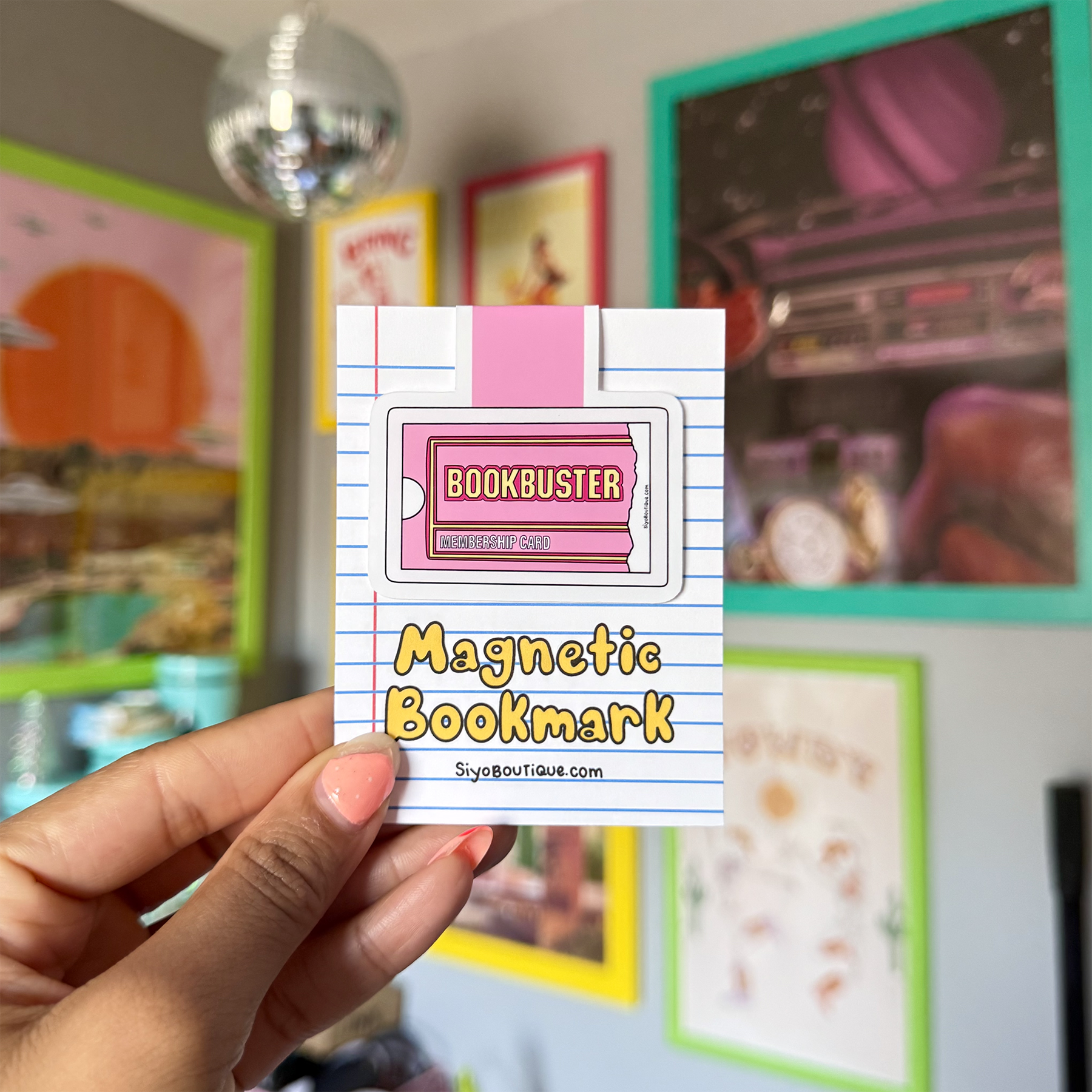 Magnetic bookmark with 'Bookbuster' design held in front of a colorful background