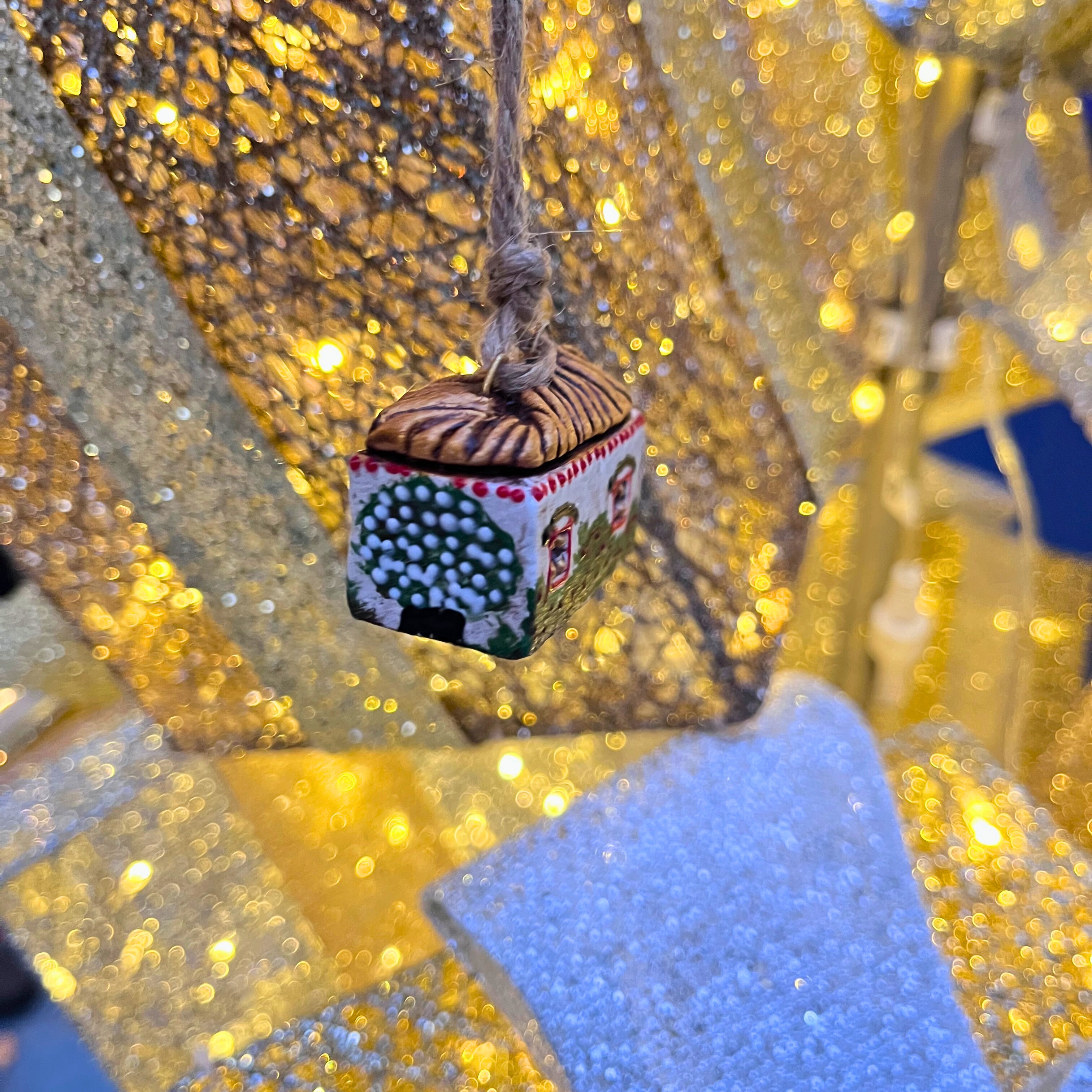 Decorative ornament resembling a house with a blurred glittery background